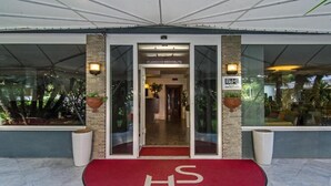 A hotel entrance with a red carpet and a glass door. - Hotel Scandinavia (Massa)