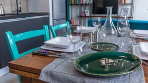 Una mesa de comedor dispuesta con platos, vasos y cubiertos en una cocina y comedor modernos.