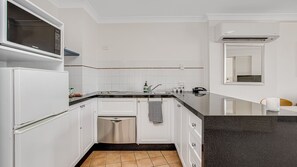 Kitchen features a microwave, stainless steel dishwasher, and sink with faucet.