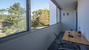 A room with a large window, a wooden table with a bottle and glasses, and a chair. - Becs Beach 500m away - Apartment for 4 (Saint-Hilaire-de-Riez)