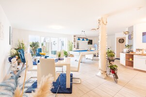 Una sala de estar moderna con comedor, mesa de billar y cocina.