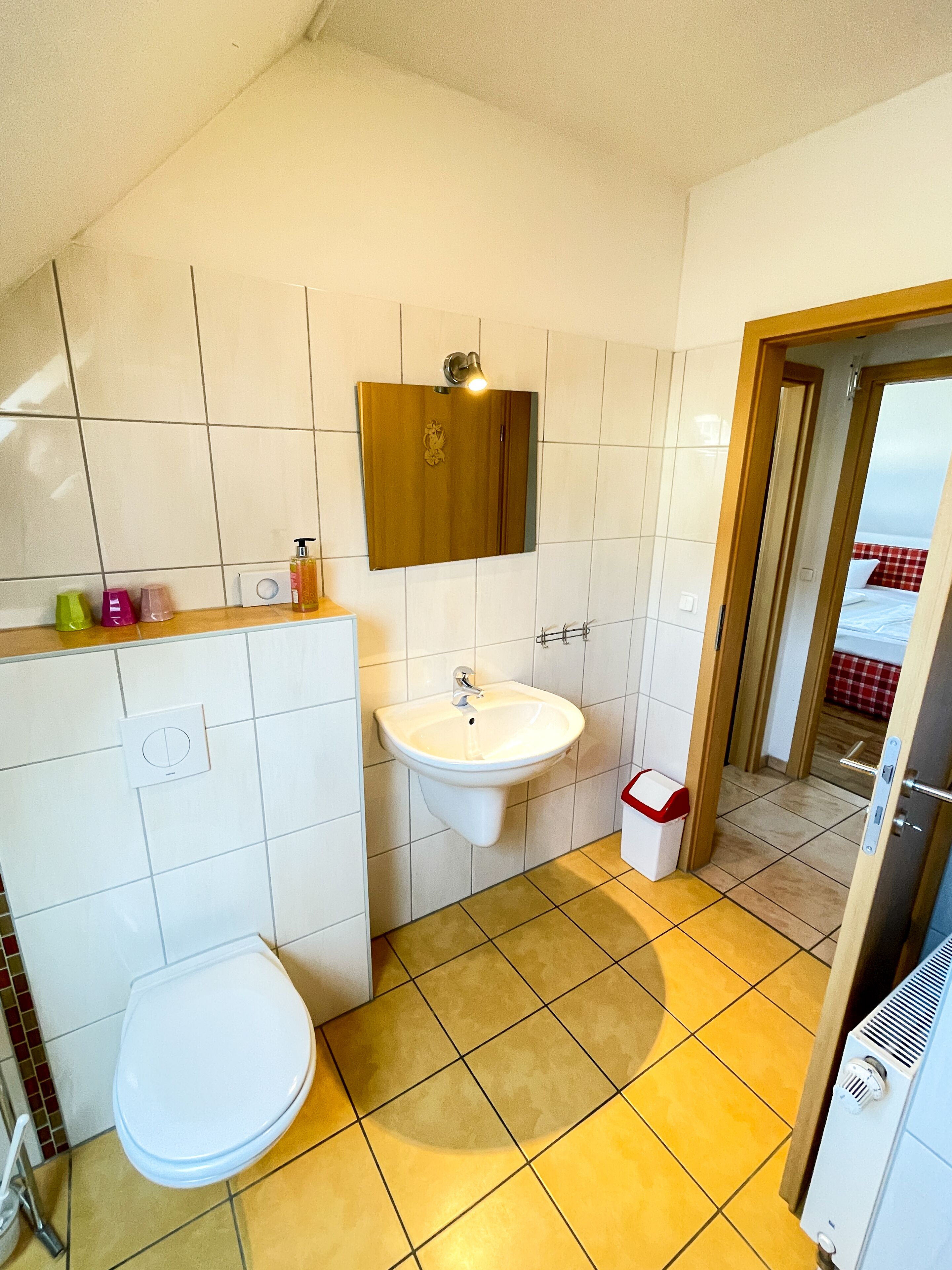 Un baño con inodoro, lavabo y espejo.