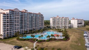 Un extenso complejo hotelero con varias edificaciones, una piscina central y zonas verdes circundantes.