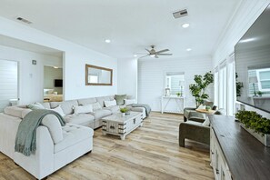 Amplia sala de estar con sofá modular, una mesa de centro y una zona comedor con banco.