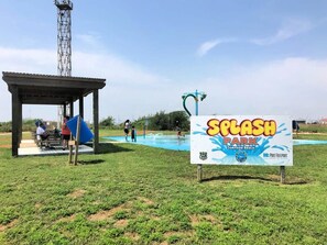 A sign for Splash Park with a pool and a covered seating area.