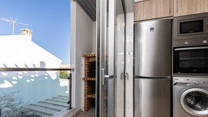 A modern kitchen with a built-in oven, microwave, and washing machine.