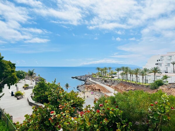 A coastal resort with a paved walkway, palm trees, and a view of the sea. - Luxury Kim Apartment, Ocean View. (Playa Paraíso)