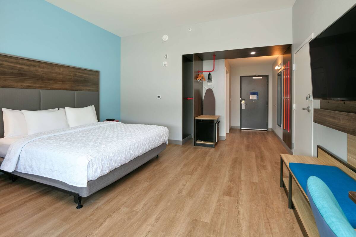 Una habitación de hotel moderna con una cama grande, una cama más pequeña y un televisor.