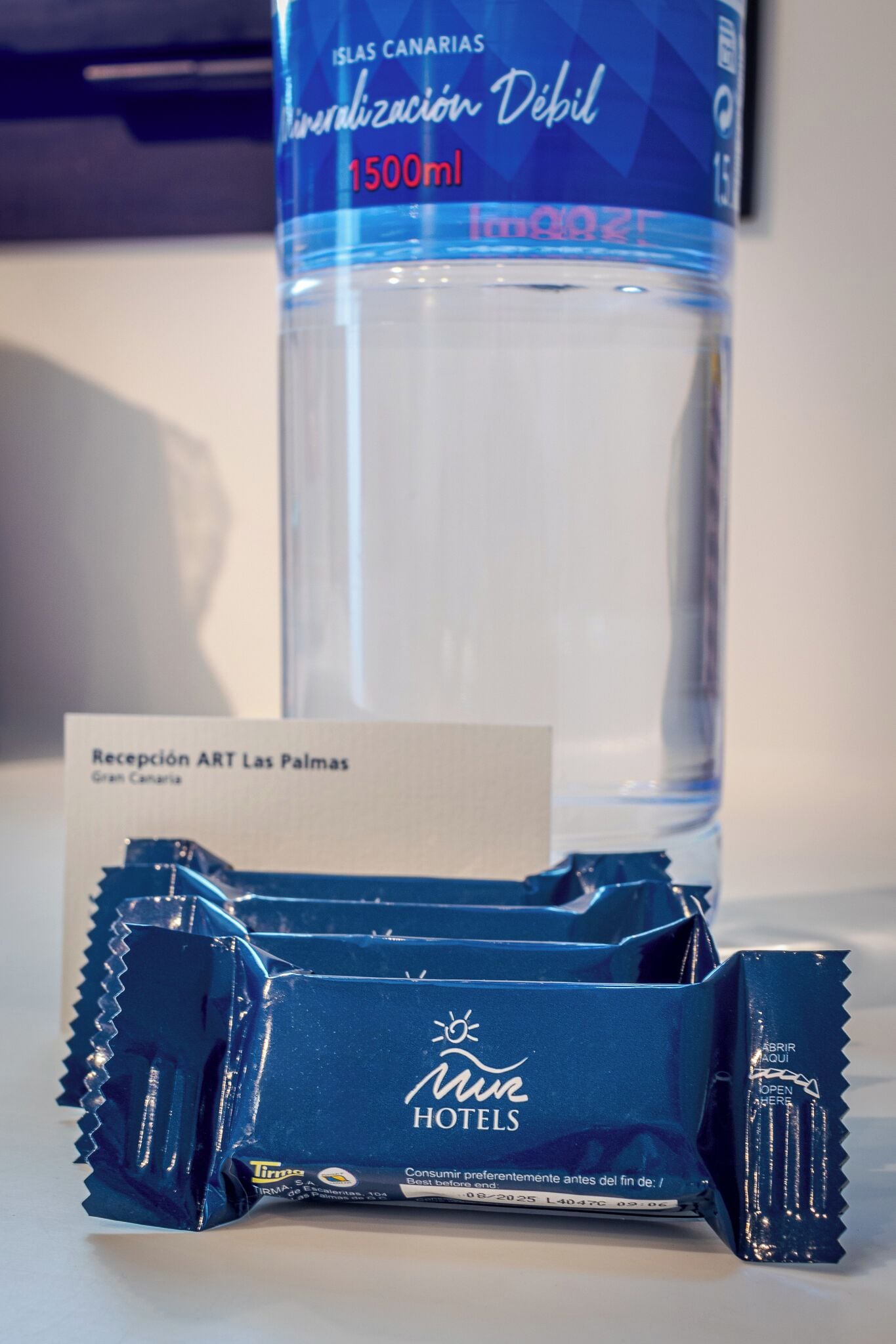 A bottle of mineral water, a hotel package, and a card.