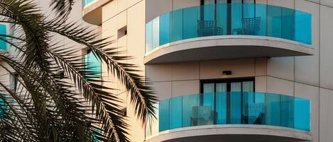 A hotel building with a sign reading "ART Hotels" and balconies with glass railings.