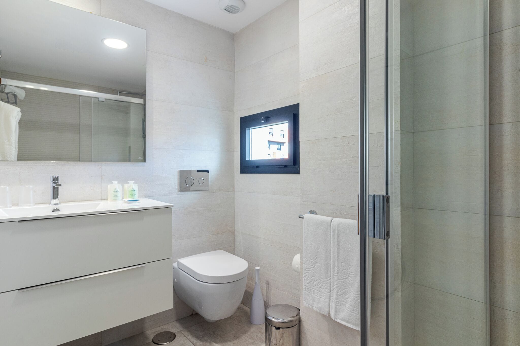 A modern bathroom with a toilet, sink, and shower area.