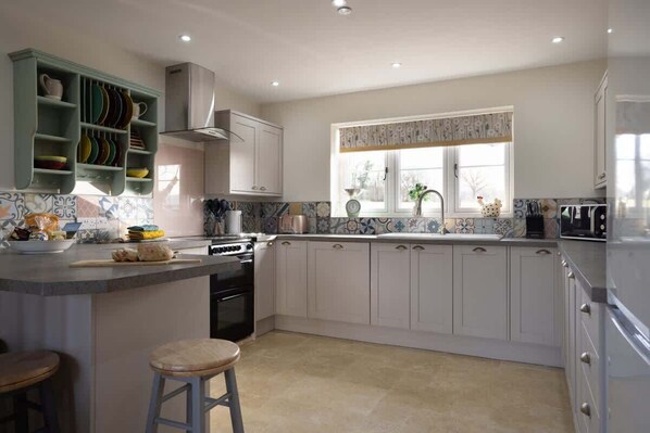 A kitchen with white cabinets, a central island, and a window with a view.