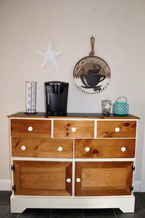 Storage and style come together in this functional chest with multiple drawers and decorative wall hanging.