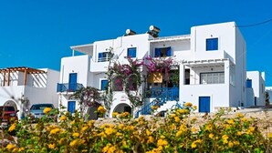 A white building with blue accents, balconies, and a clear blue sky. - Beachfront Bocamviglies Room/Naoussa Cycladic Nest (Naoussa)