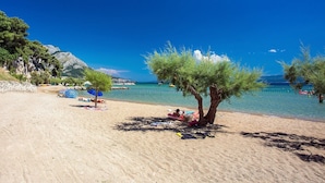 A beach with clear blue water, a few trees, and people relaxing. - Villa BAMM with heated 36sqm pool, 5 en-suite bedrooms, and panoramic sea views (Borak)