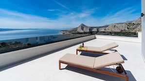A rooftop terrace with two lounge chairs, a small table with a bottle and glasses, and a clear view of the sea and mountains. - Villa BAMM with heated 36sqm pool, 5 en-suite bedrooms, and panoramic sea views (Borak)
