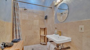 A bathroom with a shower, a sink, a mirror, and a wooden bench with towels and a hairdryer. - Cypress House & Studio, Walk To Healdsburg Plaza 3 Bedroom Home by RedAwning (Healdsburg)