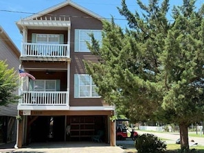 A two-story building with a garage, a balcony, and an American flag.