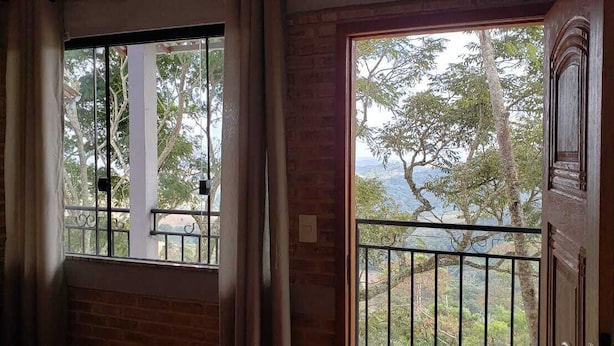 Habitación con vista a un balcón y árboles.