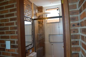 A bathroom with a shower, a toilet, and a sink.