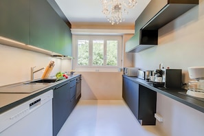Eine moderne Küche mit Geschirrspüler, Backofen und Kaffeemaschine.