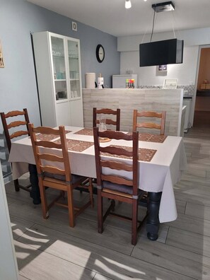 Comedor con una mesa dispuesta para cuatro personas, rodeado de sillas de madera.