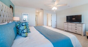 A bedroom with a large bed, a dresser, a television, and a ceiling fan. - Last Minute Disney Getaway! Private Pool, Hot Tub & Game Room. Book Now! #56487 (Orlando)