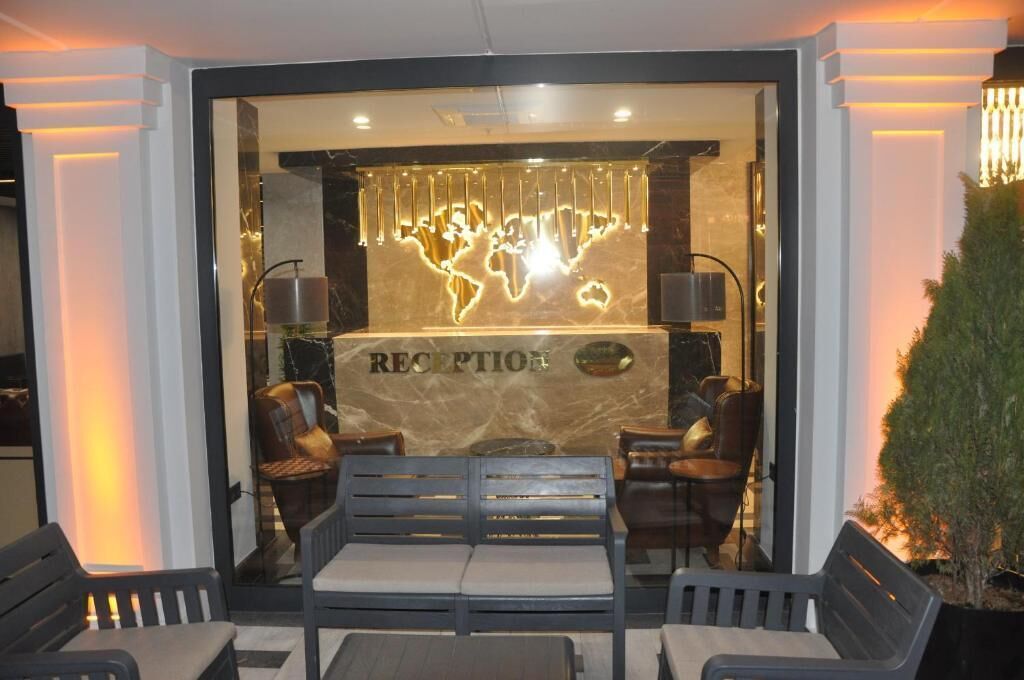 A reception area with a marble counter, two leather armchairs, and a bench.
