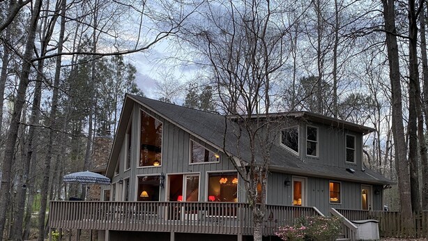 A two-story cabin with a deck, surrounded by trees. - Reduced Spring rates! On Lake Oconee with Sunset Views, 2 Masters (Eatonton)