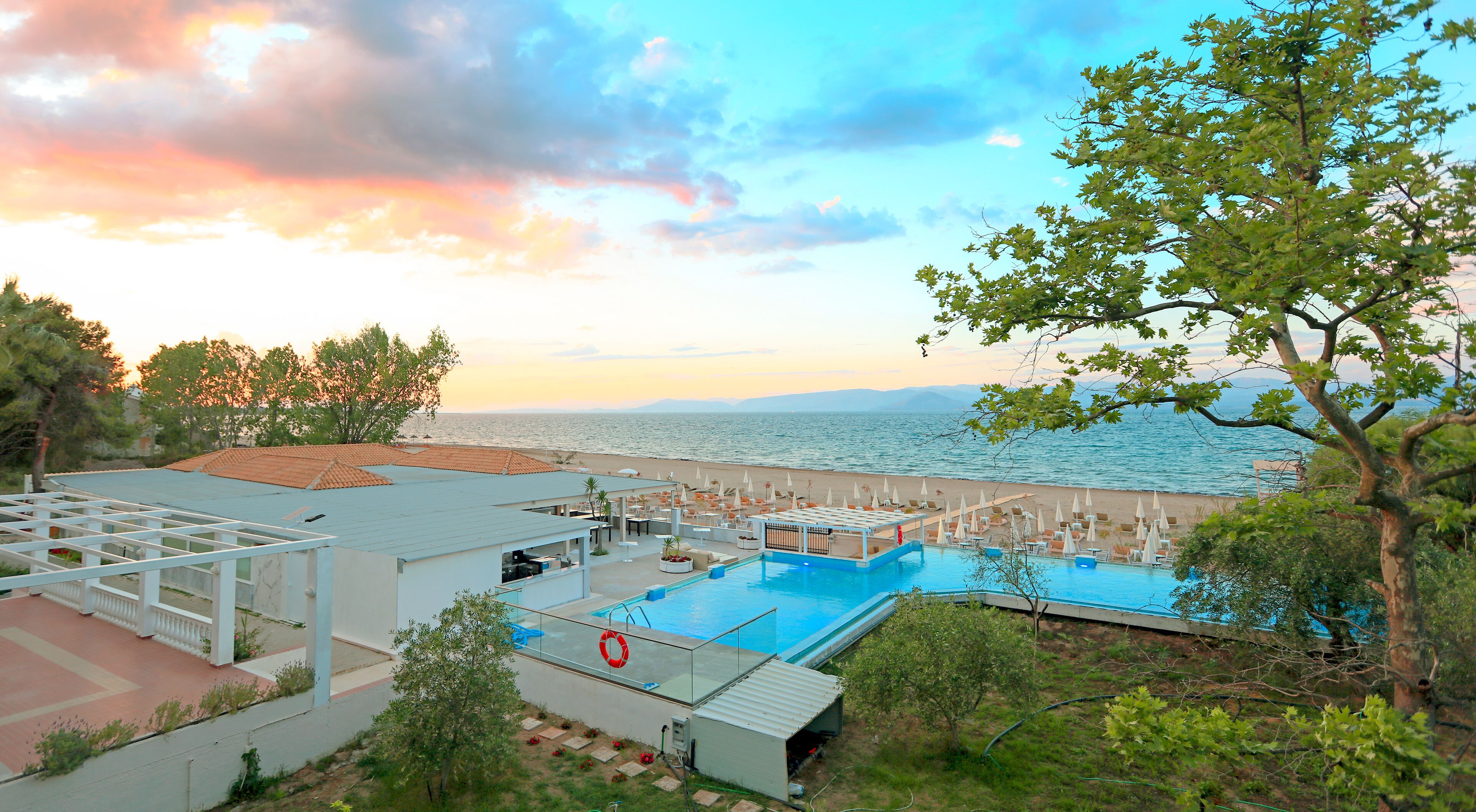 Un complexe hôtelier doté d’une piscine, d’une plage et offrant une vue sur l’océan.