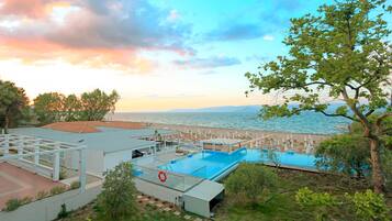 Un complexe hôtelier doté d’une piscine, d’une plage et offrant une vue sur l’océan.