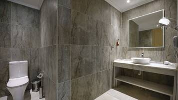 A modern bathroom with a toilet, sink, and mirror.