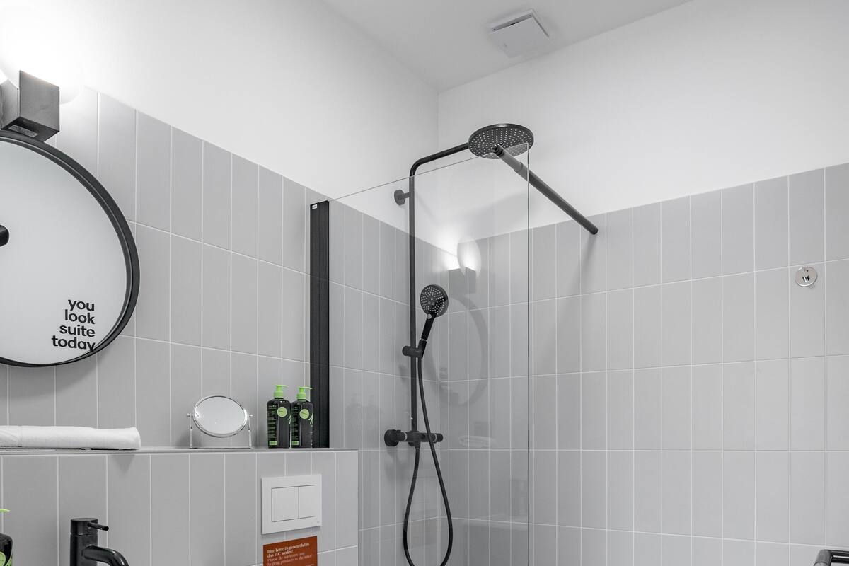 A modern bathroom with a shower, toilet, and sink.