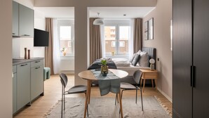 A modern apartment with a dining area, a bed, and a kitchenette. - Limehome Salzgitter A.-Schweitzer-Str. (Salzgitter)