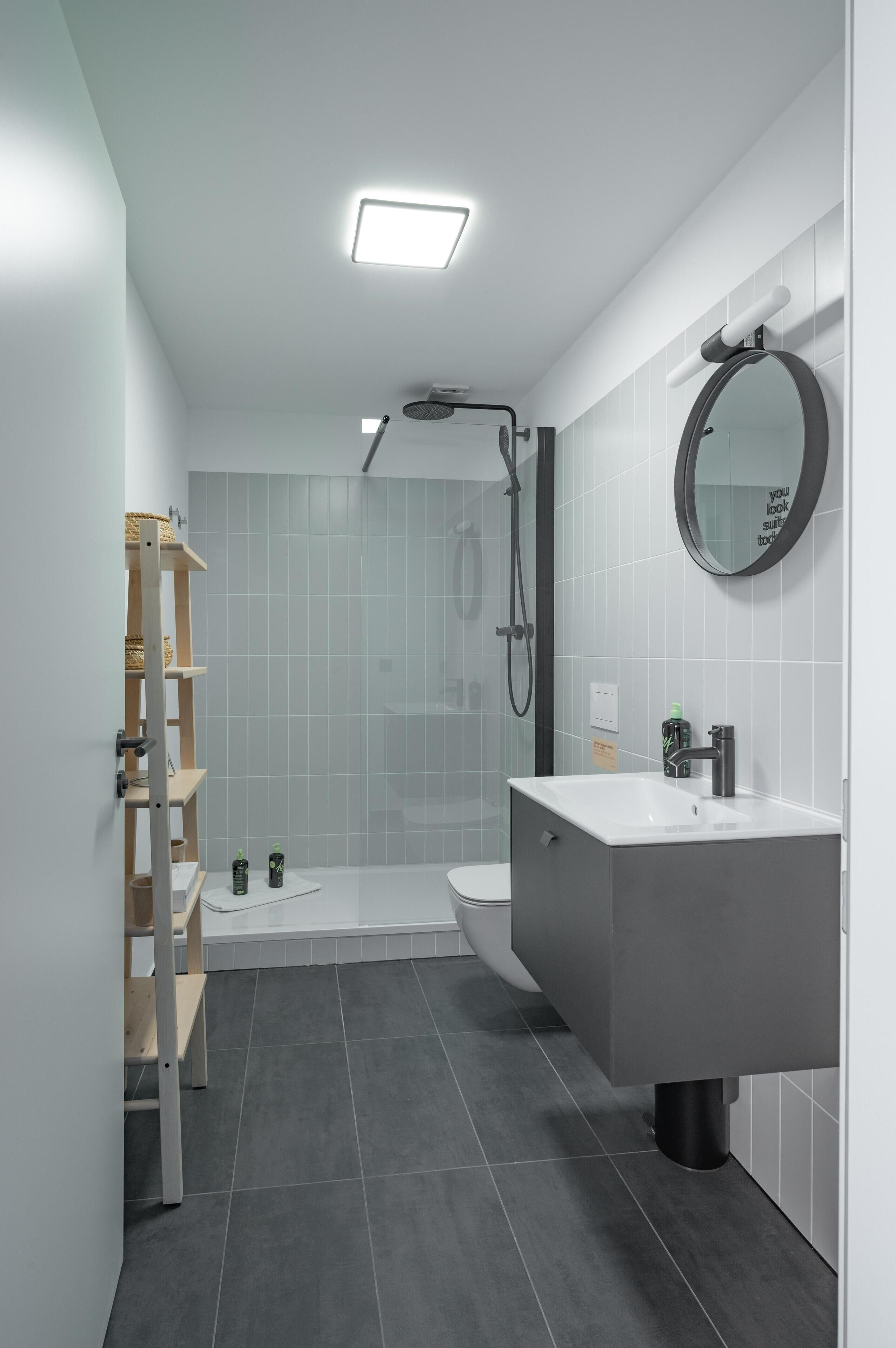 Un baño moderno con ducha, inodoro y lavamanos.