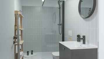 Un baño moderno con ducha, inodoro y lavamanos.