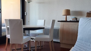 Ein modernes Wohnzimmer mit Essbereich, einer Couch und einer Lampe.