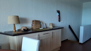 Eine Küche mit dunkler Arbeitsplatte, Holzschränken und einem weißen Stuhl.
