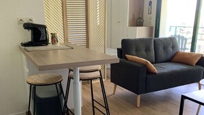 Um espaço de estar moderno com cozinha, sofá e mesa de jantar.