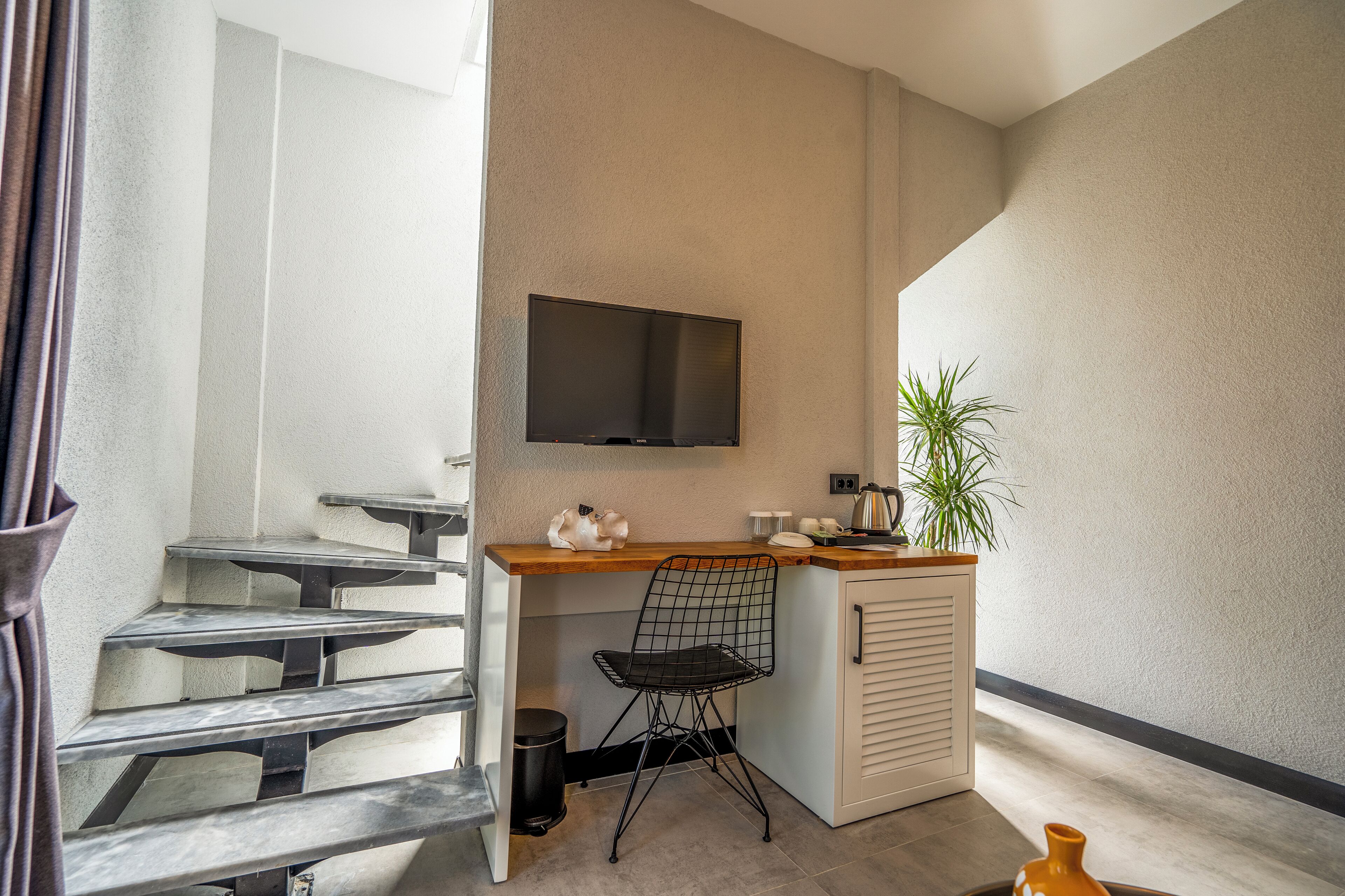 A compact kitchen area with a built-in TV, a small bar counter, and a chair.