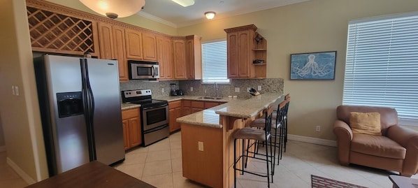 Enjoy cooking in the fully equipped kitchen with a refrigerator, microwave, and stove, and relax in the adjacent living area with a sofa.