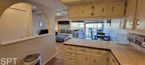 Departamento, varias camas, patio, vista al jardín | Área de sala de estar | Televisión 