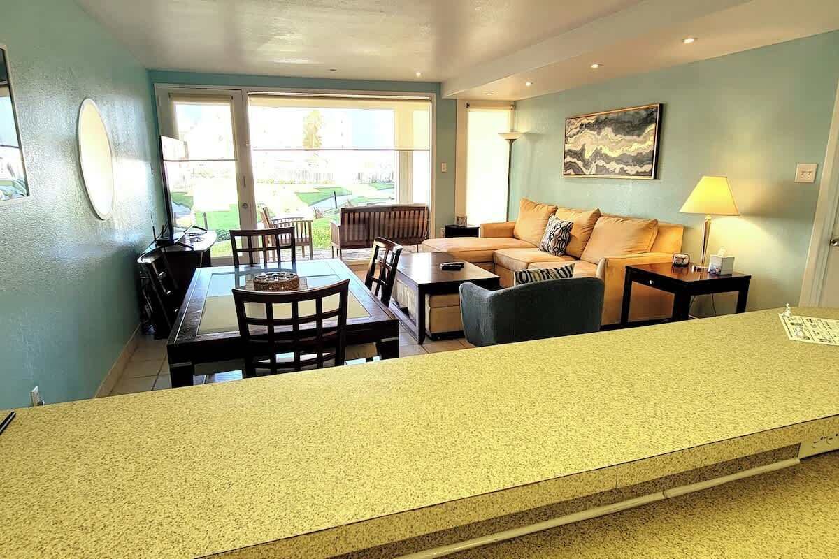 Un salon comprenant un canapé, une table basse et un coin repas avec des chaises et une table.