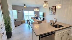 A modern kitchen with a central island, built-in dishwasher, and pendant lighting. - Bungalow Tarvana #2 (Port Isabel)