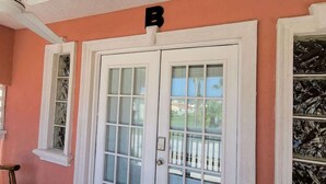 A double door with a mailbox above it, set in a building with a peach-colored exterior. - Campeche Triplex Unit B (South Padre Island)
