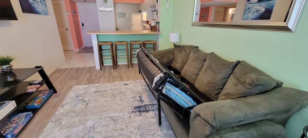 Una sala de estar con un piano, un sofá, una mesa de centro y una alfombra.