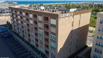 Un immeuble à plusieurs étages, nommé « GULFVILLE », avec un parking situé devant.