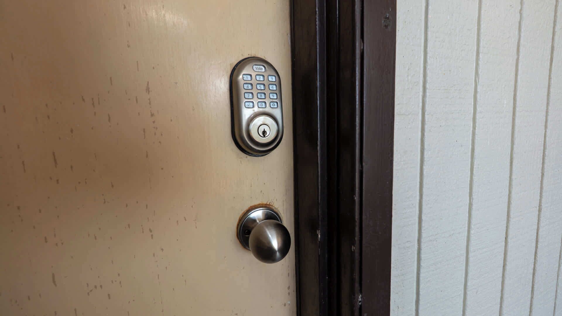 Uma porta com fechadura Yale e uma fechadura.