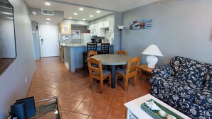 A compact living space with a dining area, kitchen, and a sofa.