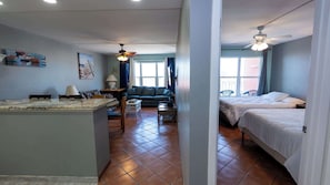 A compact hotel room with a kitchenette, a sofa, a bed, and a ceiling fan. - Gulfview II #604 (South Padre Island)